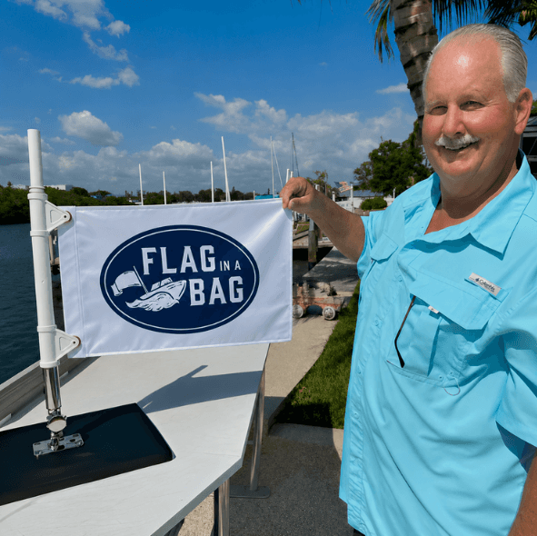 Doug Jennings holding a 'Flag in a Bag' product with a scenic background