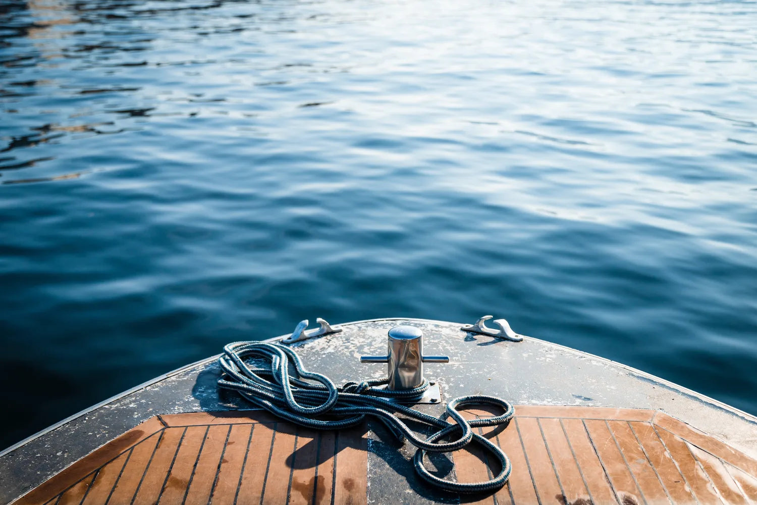 Rope coiled on a boat deck with water in the background